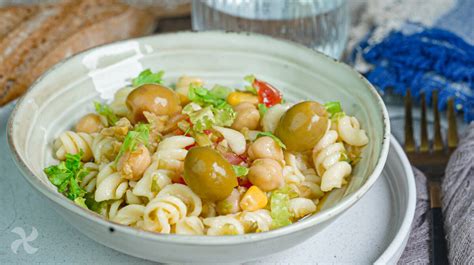 Plato de ensalada de garbanzos, pasta y espinacas con aderezo fresco