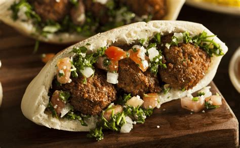 Variedad de platos de comida callejera como shawarma, falafel y gyros con salsas de yogur