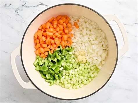 Verduras picadas (cebolla, ajo, zanahoria, apio) sofriéndose en una olla