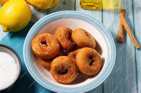 Foto de rosquillas fritas rebozadas en azúcar y canela, presentadas de forma apetitosa.