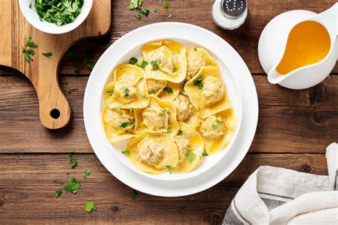 Plato de ravioles artesanales de ricota y nuez servidos con una salsa suave de manteca y salvia