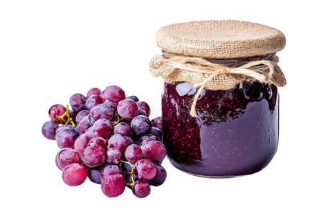 Imagen de una mermelada de uva artesanal en un frasco de vidrio junto a una tostada y uvas frescas sobre una mesa de cocina.