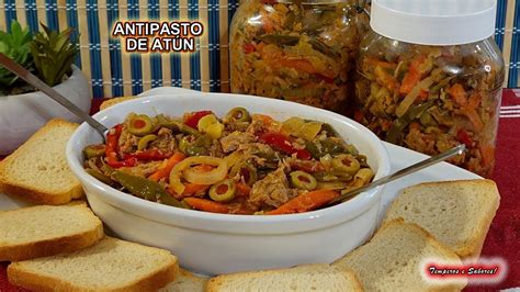 Imagen de un antipasto de atún venezolano servido en un recipiente de cristal acompañado de galletas saladas y pan tostado.