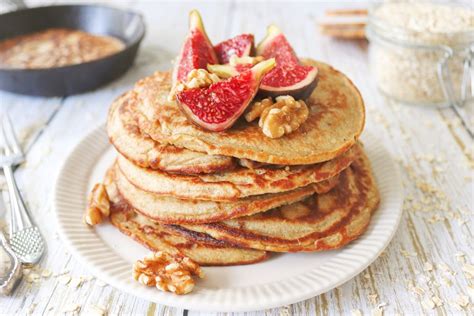 Mesa con variados toppings para panqueques de avena: frutas, miel, frutos secos