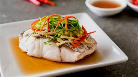 Imagen de un trozo de pescado blanco cocido al vapor, sin espinas, sobre un plato para perros