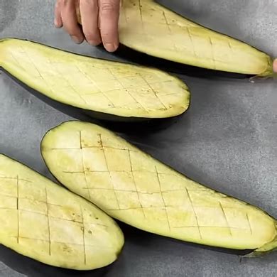 Berenjenas horneadas doradas en una bandeja con papel de horno