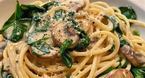 Disposición de ingredientes frescos: espinacas, champiñones, cebolla, ajo, queso, pasta.