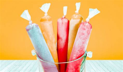 Imagen de helados marcianos de distintos sabores presentados en sus bolsitas tipo tubo sobre un fondo veraniego.