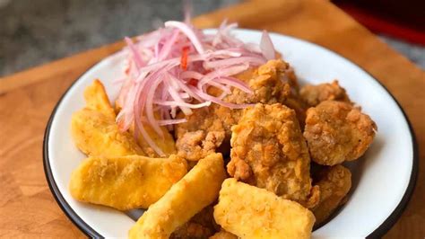 Plato de chicharrón de pollo peruano servido con acompañamientos