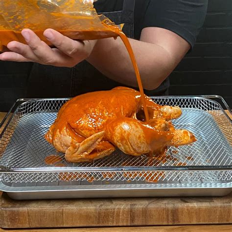 Pollo marinándose en un recipiente refrigerado