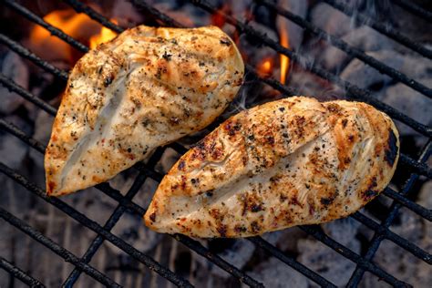 Foto de pollo a la parrilla perfectamente dorado y jugoso, acompañado de vegetales a la brasa