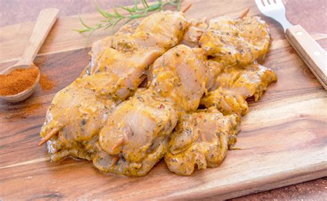 Foto de pollo marinado con especias caribeñas listo para la parrilla