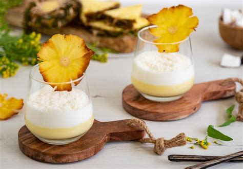 Mousse de piña y coco en copas individuales decorado con coco rallado y trozos de piña
