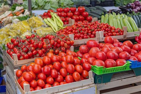Mercado de agricultores con tomates frescos y alcachofas en puestos de venta