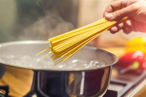 Olla profunda con agua hirviendo y pasta integral