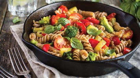 Plato de pasta integral con verduras y salsa