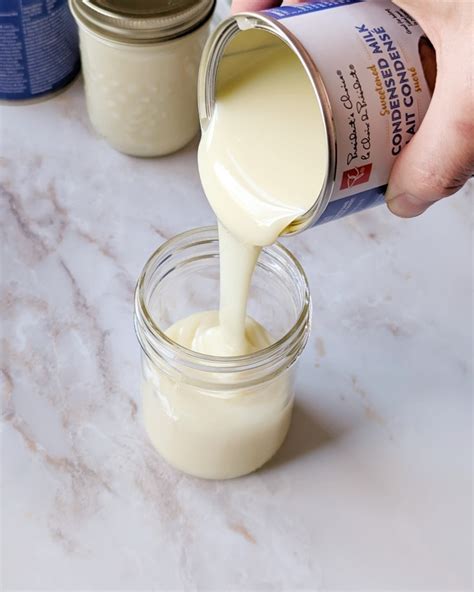 Latas de leche condensada hirviendo en una olla para hacer dulce de leche