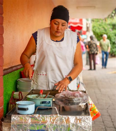 Mujer cocinando con un delantal tradicional en una cocina antigua