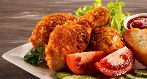 Foto de pollo frito colombiano casero dorado y crujiente, servido en un plato
