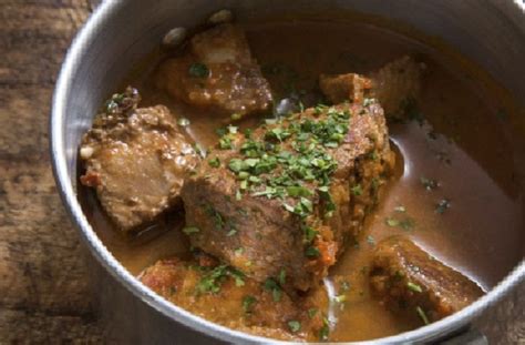 Cabrito al jugo a la chilena servido en plato tradicional con papas