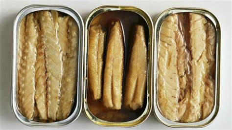 Imagen de latas de conservas de pescado, algunas etiquetadas como jurel, para ilustrar el tema de la falsificación.