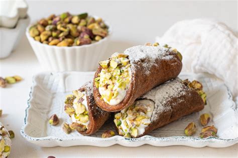 Foto de cannolis horneados rellenos, espolvoreados con pistachos