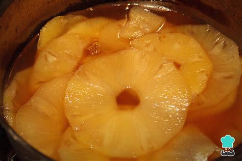 Tarros de piña en almíbar hirviendo para esterilización