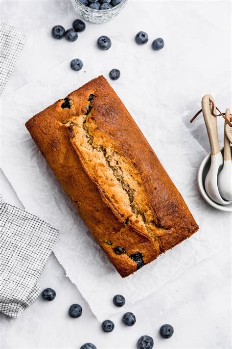 Molde rectangular con masa de queque de plátano y arándanos, con tiras de mantequilla fría dispuestas en el centro.