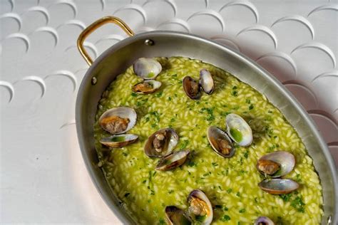 Plato de arroz meloso con almejas y perejil fresco