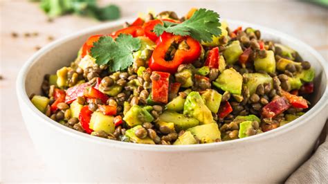 ensalada colorida de lentejas con verduras frescas, aguacate y trozos de fruta