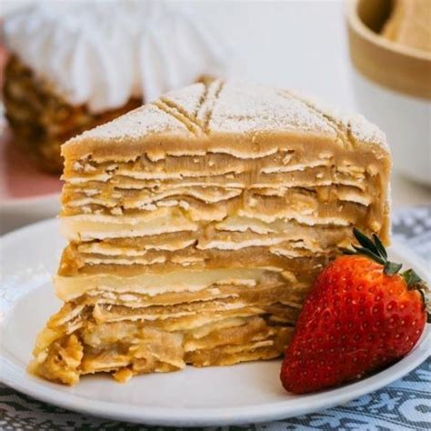 Fotografía de una torta tradicional chilena de milhojas con manjar y crema pastelera, mostrando las capas y el relleno.