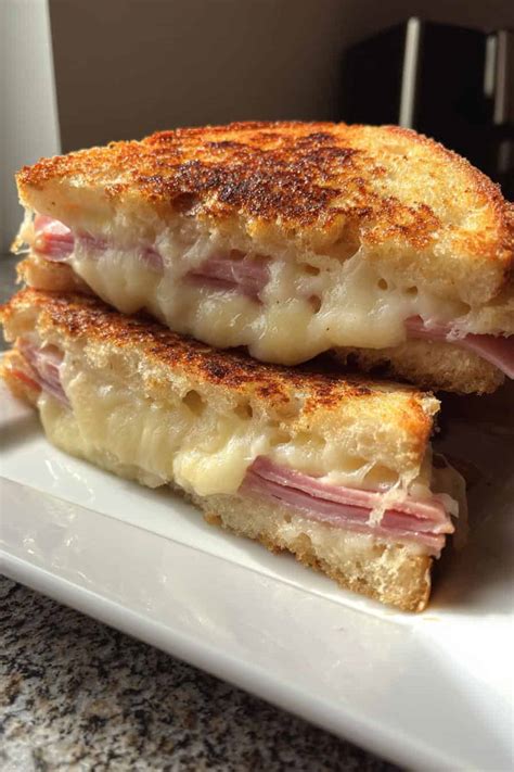 Sandwiches calientes de jamón y queso cortados en triángulos pequeños