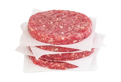 Imagen de hamburguesas crudas reposando en un plato en la nevera.