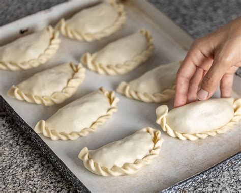 Empanadas individuales doradas sobre papel de horno