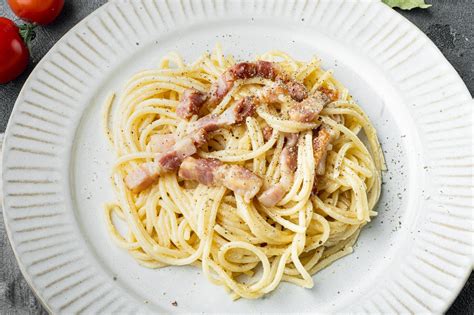 Foto de un plato de espaguetis carbonara con guanciale crujiente y salsa cremosa