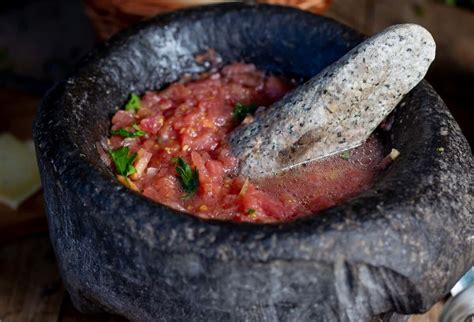 Mortero de piedra tradicional chileno con ingredientes para chancho en piedra.