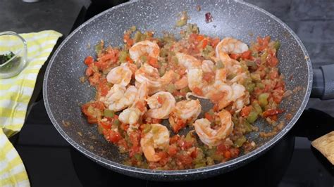 Primer plano de los camarones cocinándose en el sartén con la salsa caribeña.