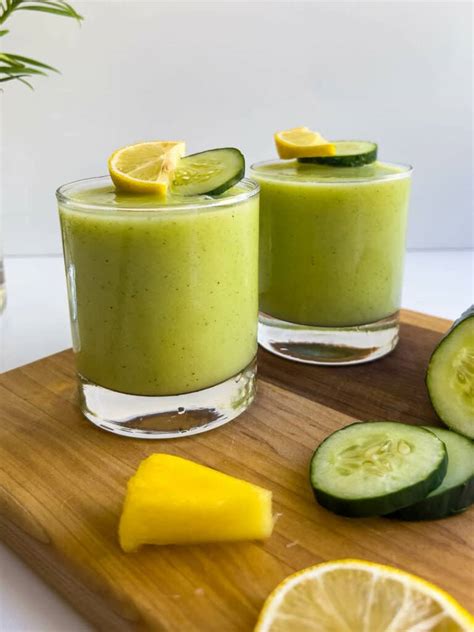 Vaso de batido de piña y pepino listo para beber, con rodajas de fruta