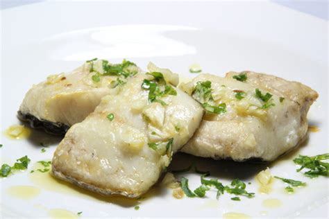 Lomos de merluza con rodajas de limón y hierbas aromáticas antes de cocción al vapor