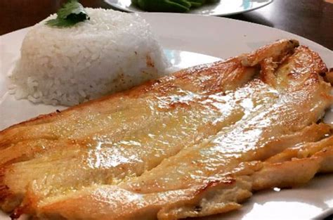 Fotografía profesional de un filete de reineta dorado a la plancha con hierbas frescas