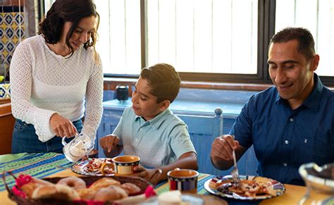 Familia desayunando alimentos saludables en la mesa