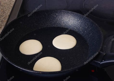fotografía de panqueques dorándose en una sartén