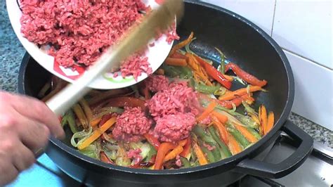 Imagen de vegetales sofritos y carne molida dorándose en una sartén.