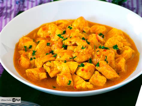 Plato de pollo al curry thai emplatado con decoraciones de cilantro y maní