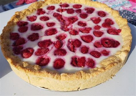 Foto de un kuchen de frambuesa recién horneado, con la masa dorada y frambuesas frescas por encima.