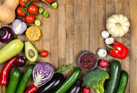 Variedad de frutas y verduras coloridas en un cuenco o sobre una mesa de madera, simbolizando la abundancia y la salud.