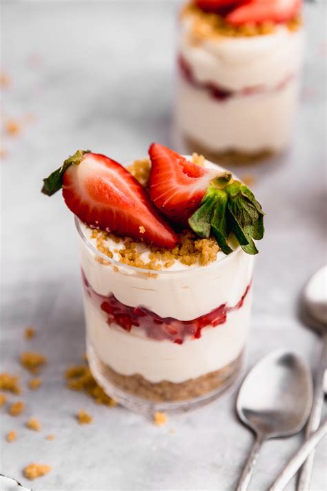 Esquema visual mostrando el montaje por capas de un cheesecake en vaso: base de galleta, capa de queso y topping de frutos rojos.