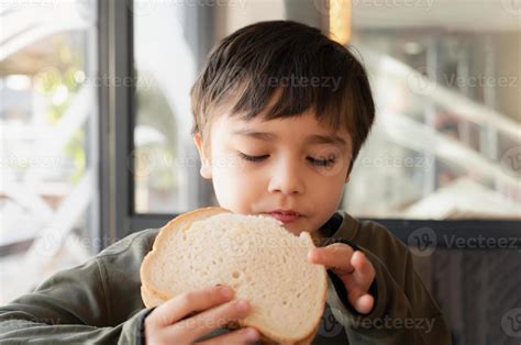 Imagen de un niño comiendo un sándwich de pan integral saludable.