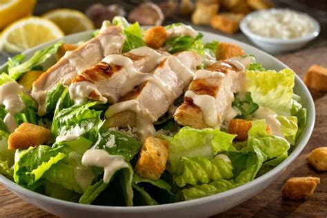 Plato de Ensalada César con pollo a la parrilla, lechugas variadas y croutons.