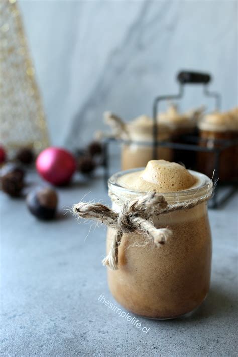 Foto de una Cola de Mono vegana servida en un vaso con una ramita de canela